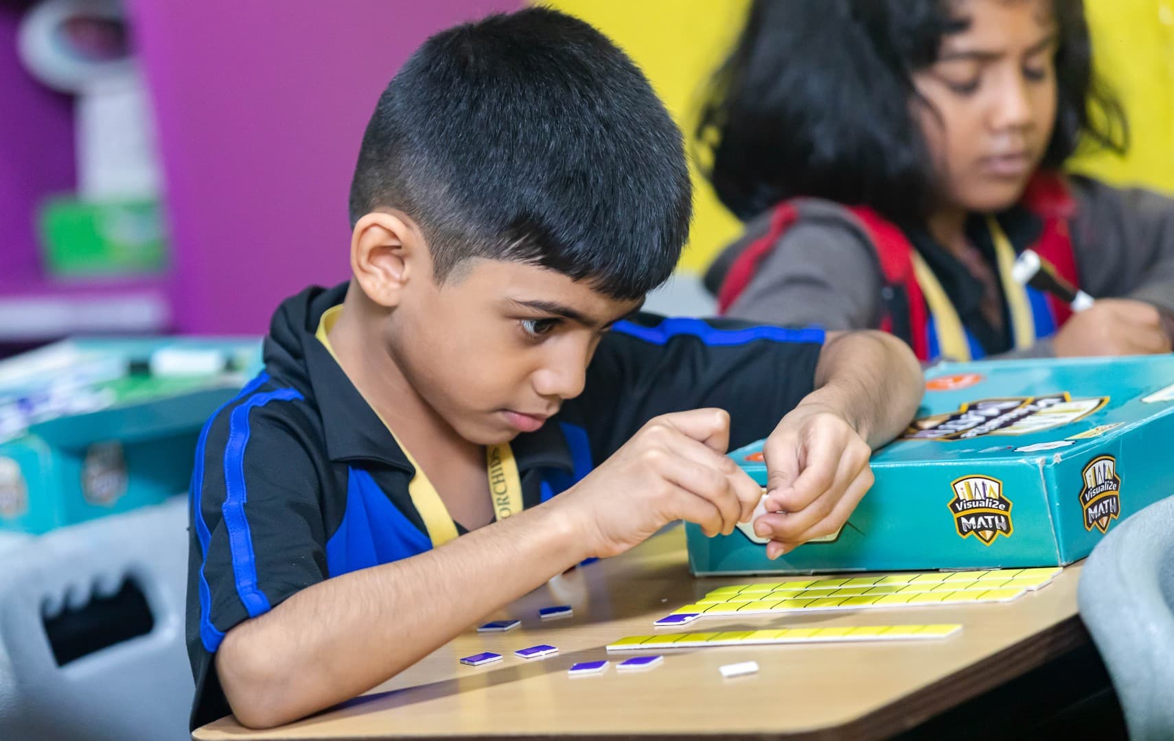 Young students are learning math in a visual and interactive way using colorful blocks and engaging activities
