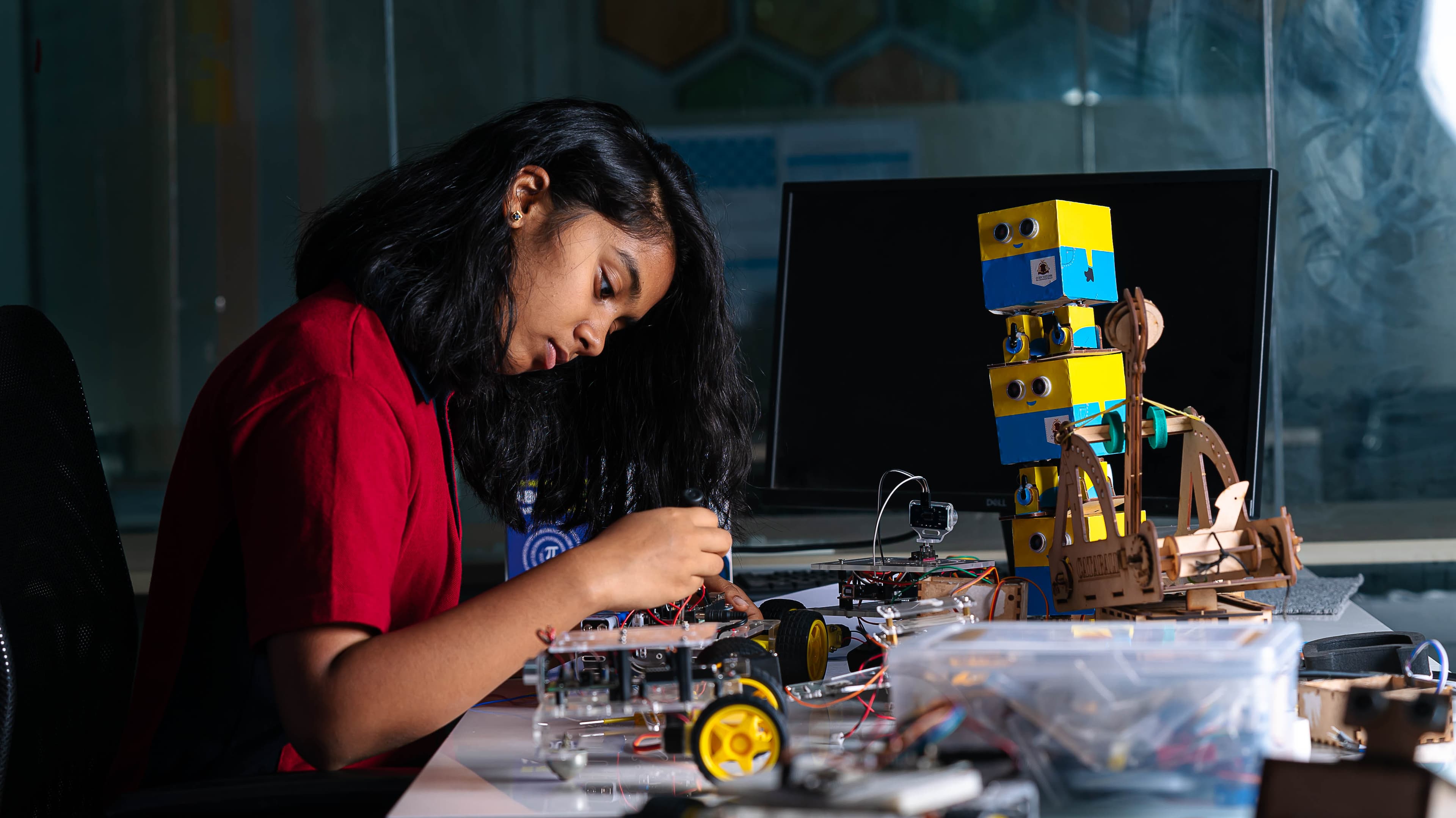 A student programming a robot in the Robotics laboratory at Orchids International School